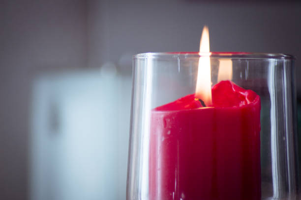 Bougie rouge brûlante à l’intérieur d’un vase en verre clair. Pas de gens