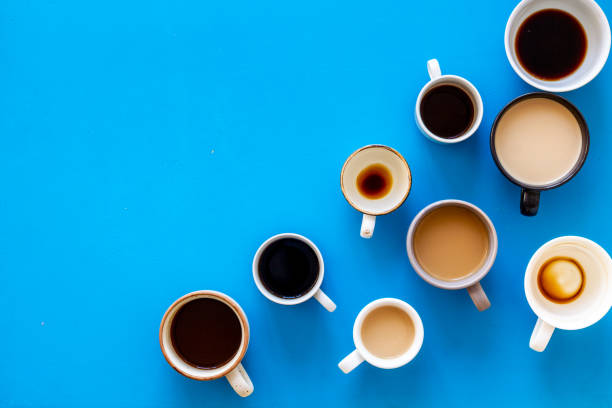 istock Cups of hot drinks on blue background from above frame copy space 1224418741