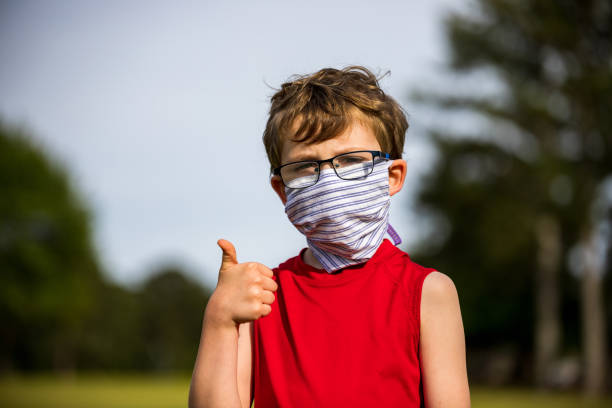 istock Person gives thumbs up while wearing mask 1224419492