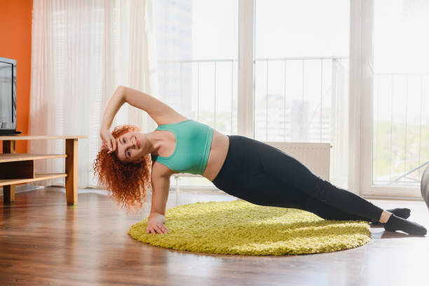istock Woman in side plank during home training 1224420083