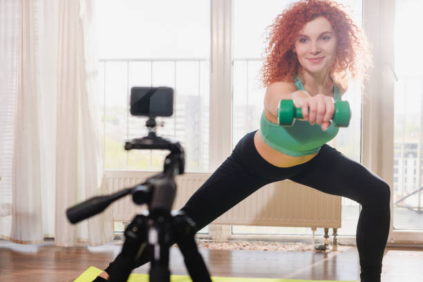 istock Woman roll dumpbells for stretching home video 1224420344
