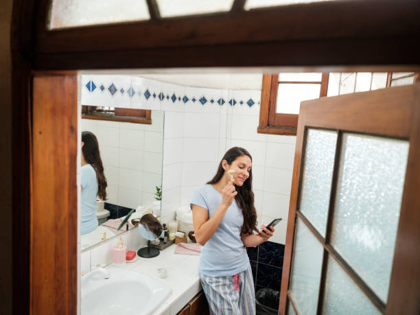 istock Latin woman using a facial massager tool in bathroom 1224421088