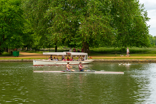 A party boat and row boat on the Thames at Oxford, Oxfordshire, England,UK.