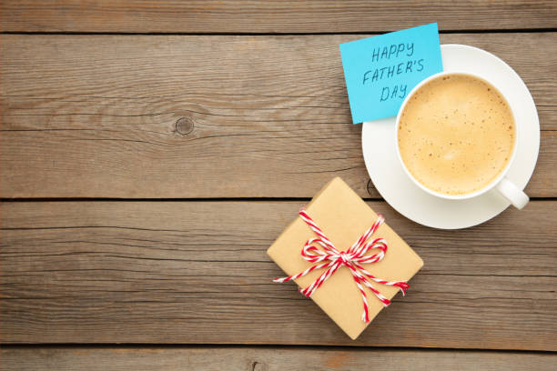 istock Fathers Day message with coffee cup and gift on grey wooden background 1224427593