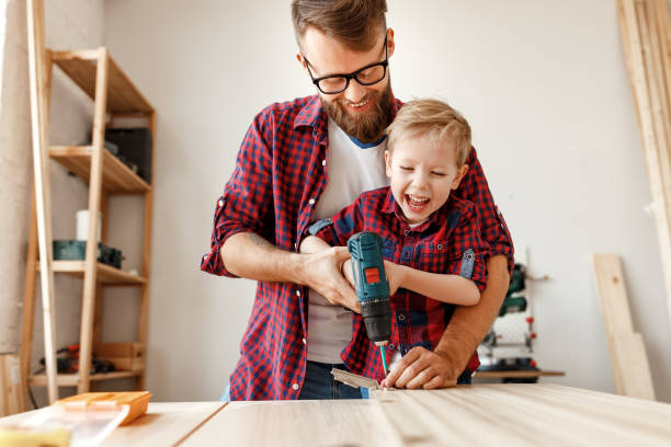 istock Happy kid helping father in carpentry studio 1224428259