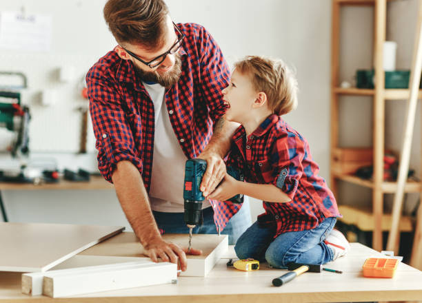 istock Happy father and son assembling furniture on table 1224429857