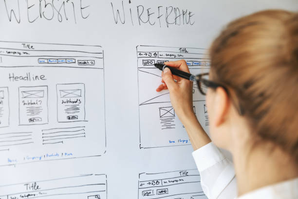 UI UX designer drawing new website wireframe UI UX designer drawing new website wireframe user experience photos stock pictures, royalty-free photos & images