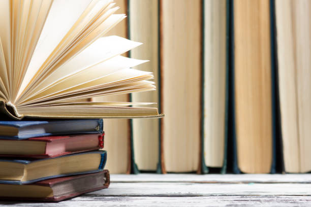 istock Open book, hardback books on wooden table. Back to school. Copy space. 1224437074