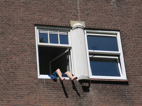 staying home during corona: sunning with your legs hanging out of the window
