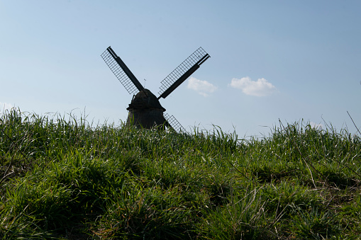 Windmill between meadows and fields in Melle district of Hoyel in Lower Saxony. A photo against the light.