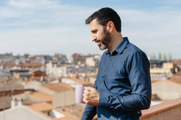 istock Middle-aged man standing on balcony drinking coffee 1224441955
