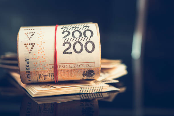Pile And Roll Of Polish Paper Money. Close Up Of Large Stack And Roll Of Polish Two Hundred Zloty Paper Currency Sitting On To Of Table. polish zloty photos stock pictures, royalty-free photos & images