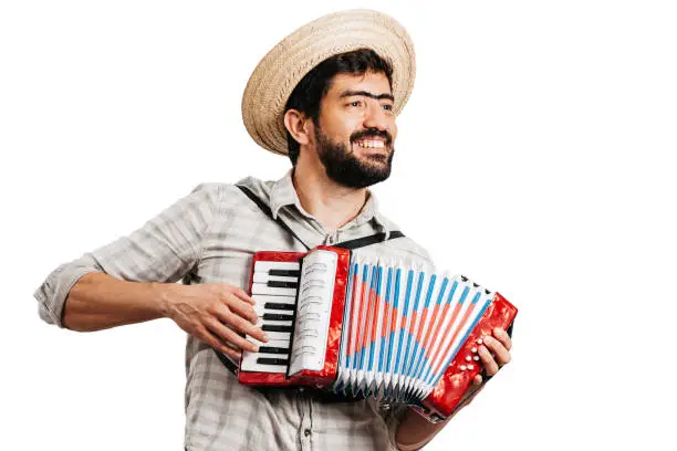 Photo of Brazilian man wearing traditional clothes for Festa Junina - June festival - playing toy accordion