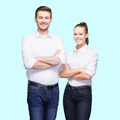 Two people of aged 20-29 years old who is beautiful caucasian young male standing in front of blue background wearing button down shirt who is confident with arms crossed