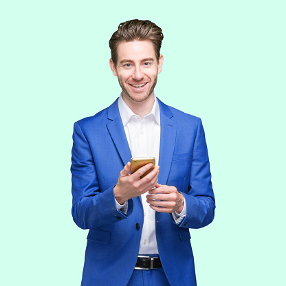 One person of aged 20-29 years old who is slim with short hair caucasian young male business person standing wearing businesswear who is cheerful and using mobile phone