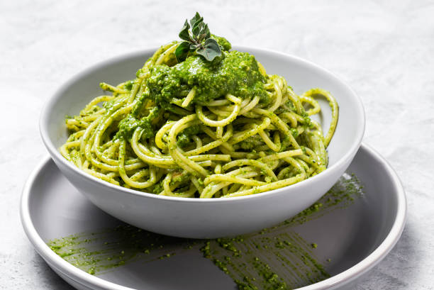 istock Spaghetti with homemade pesto sauce on gray background 1224447365