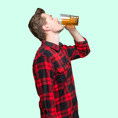 Waist up of with short hair caucasian young male standing wearing lumberjack shirt who is drinking and holding mug