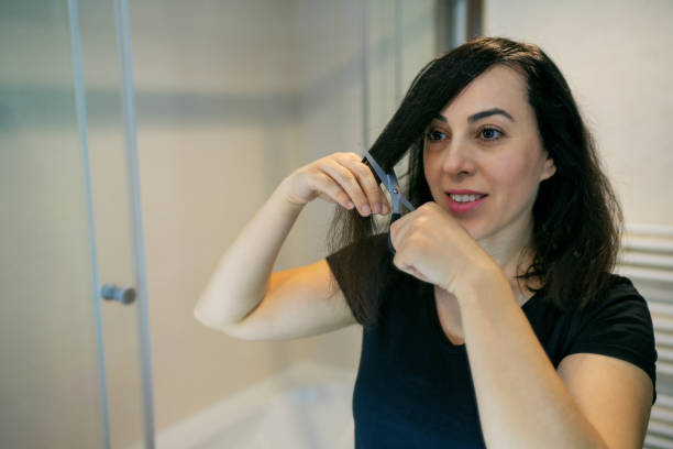 istock Woman cuts her own hair 1224448913