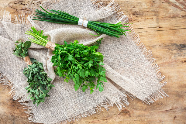 Assortment of fresh aromatic herbs from above on old wood background. Parsley, Mint, Thyme, Basil, Oregano, Rosemary, Chives and estragon.Flat lay.Top view