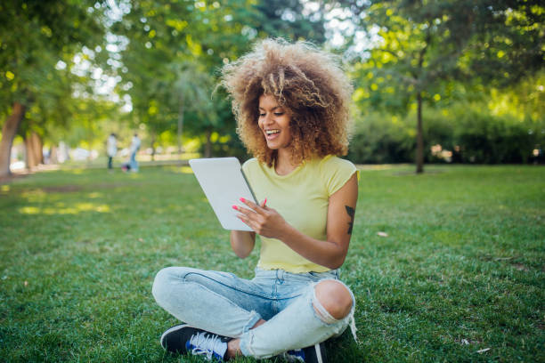 istock Cool Afro woman using tablet in the park 1224452476