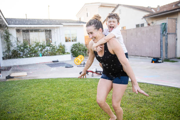 istock Mom and Son running through sprinklers after workout 1224452706