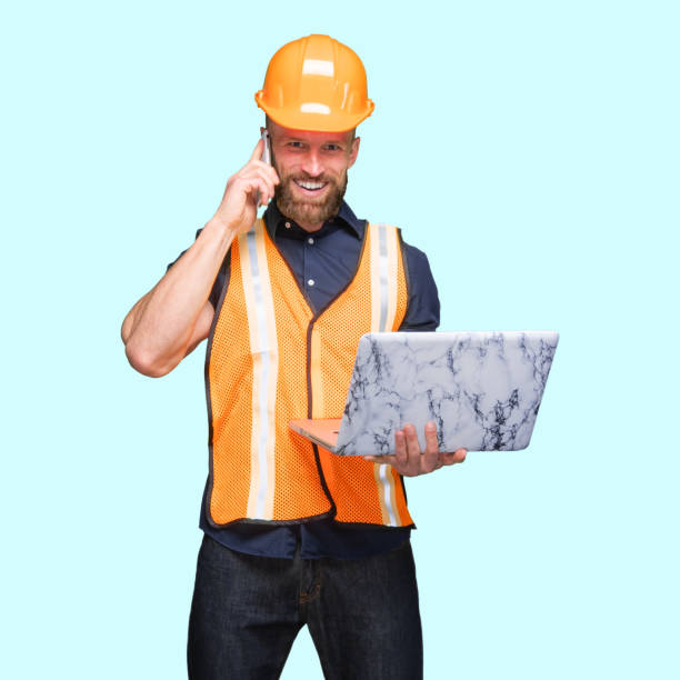 istock Caucasian male standing in front of blue background and using computer 1224457723