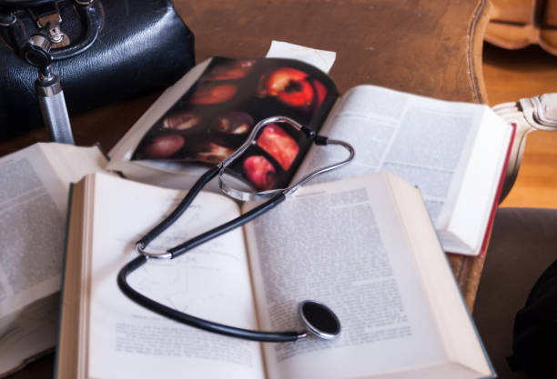 Old Fashioned Doctor's Bag Stethoscope and Medical Books Vintage doctor's bag, stethoscope,otoscope and text books on a table. leather medical bag stock pictures, royalty-free photos & images