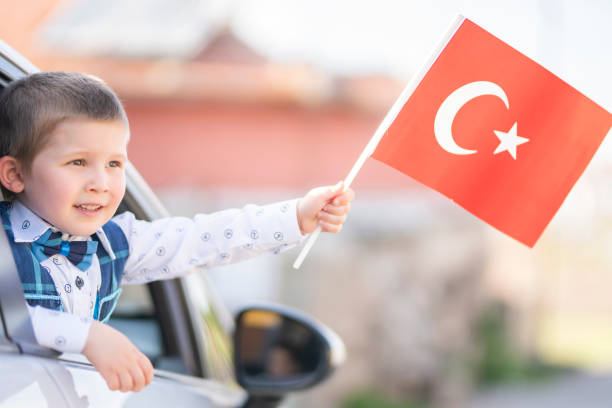istock boy holding turkish flag in car 1224461523