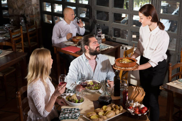 istock Waitress bringing dishes to guests 1224462730