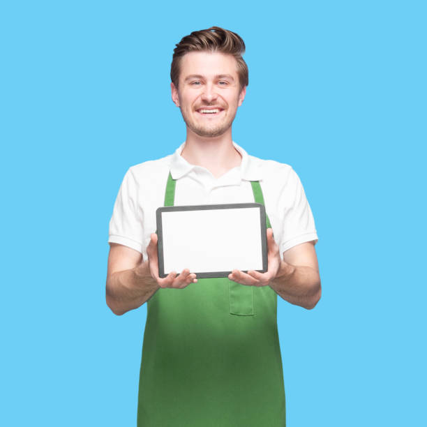 istock Caucasian male barista standing wearing apron and using digital tablet 1224465910