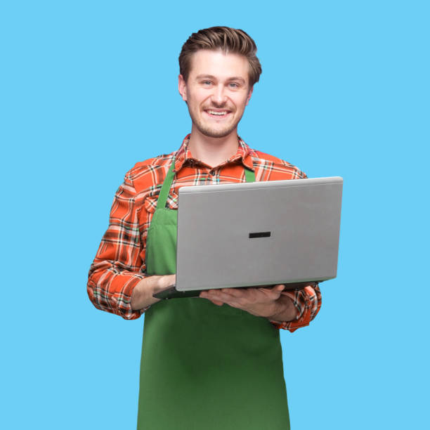 istock Caucasian young male barista standing wearing plaid shirt and using computer 1224467137
