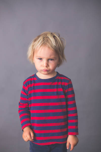 Child, boy, showing different emotions Child, boy, showing different emotions, isolated shot on gray background child laughing hysterically stock pictures, royalty-free photos & images