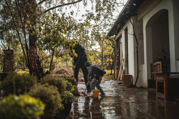 istock Father and son sweeping water from front yard on rainy day 1224472710