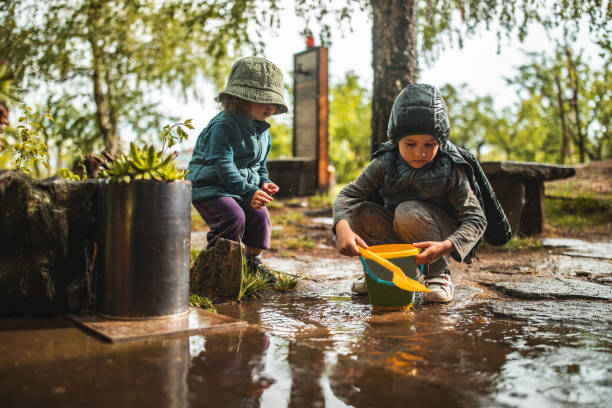 istock Brother and sister playing in front yard after rain 1224473155