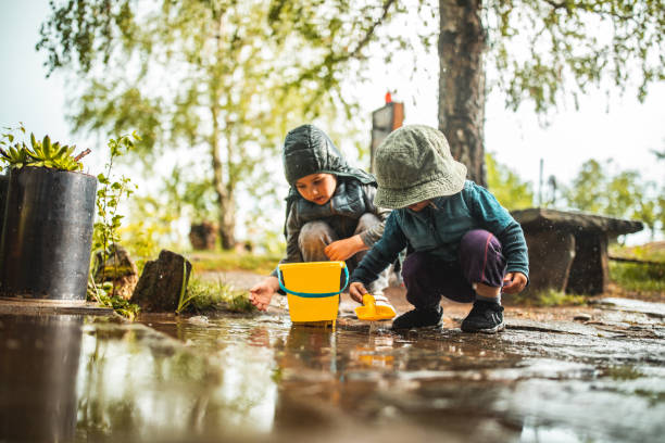 istock Brother and sister playing in front yard after rain 1224473741