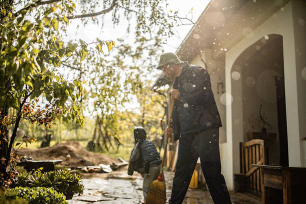 istock Father and son sweeping water from front yard on rainy day 1224474281