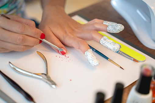 Removing nail polish from hand fingers with foil, beauty nail work tools