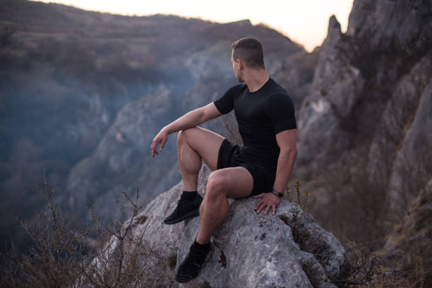 istock Strong man sitting on the mountain rock 1224477107