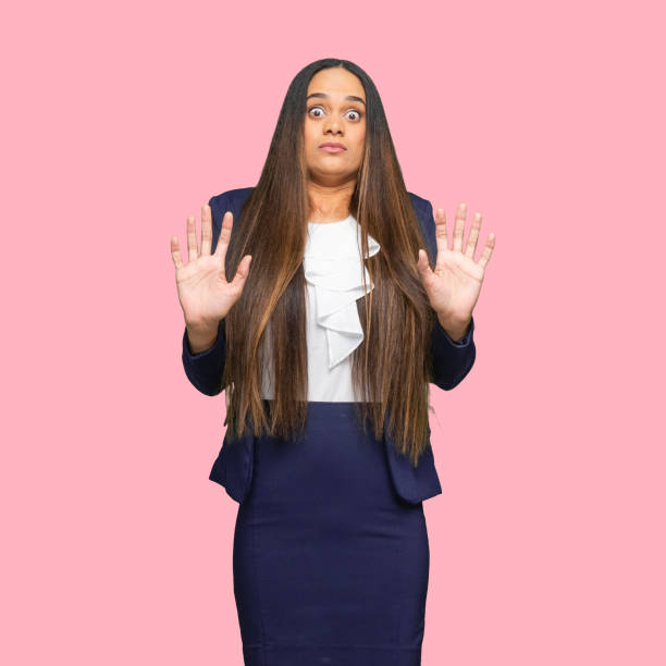 African ethnicity female manager standing in front of colored background wearing jacket Front view of aged 30-39 years old who is beautiful african ethnicity female manager standing in front of colored background wearing jacket who is phobia embarrassment skirt photos stock pictures, royalty-free photos & images