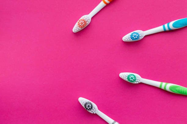 istock Multicolored toothbrushes on a pink background. The view from the top. Close up. 1224479311
