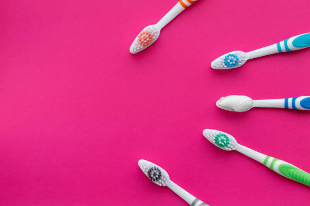 istock Multicolored toothbrushes on a pink background. The view from the top. Close up. 1224480595