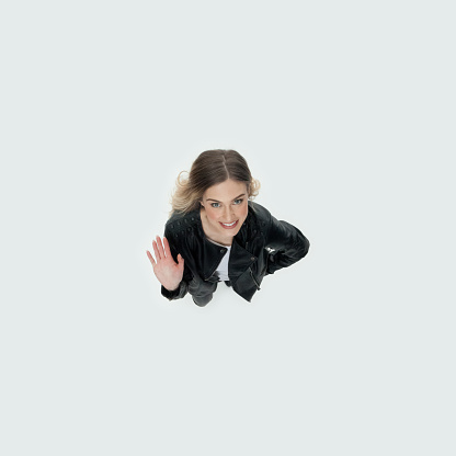 Directly above view of aged 20-29 years old who is beautiful with long hair generation z young women standing in front of white background wearing boot who is excited and greeting and showing high-five