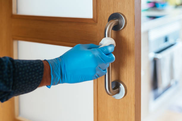 istock Close up view of hand using antibacterial wet wipe for disinfecting the door handle. 1224485549