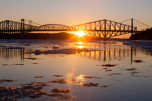 Sun setting behind Quebec City bridge on cold winters day.