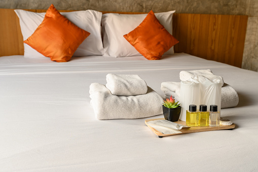 Pillows arranged on bed, all white bedding, copy space