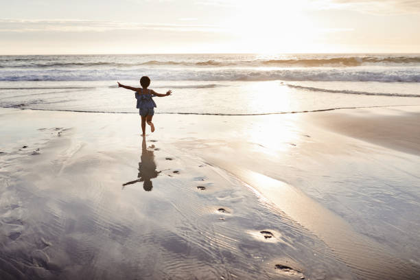 nature brings fun into our lives - child rear view running nature imagens e fotografias de stock