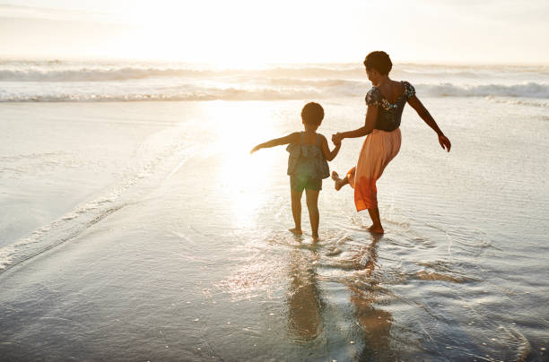 Family time is fun time Shot of a young woman spending time at the beach with her adorable daughter black african girls pictures stock pictures, royalty-free photos & images