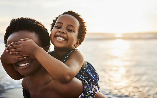 Shot of a young woman spending time at the beach with her adorable daughter