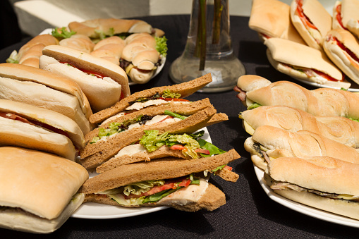Close up of fresh display of stacked pile of panini bread mozzarella melted cheese sandwiches and vegetarian a  buffet catering.