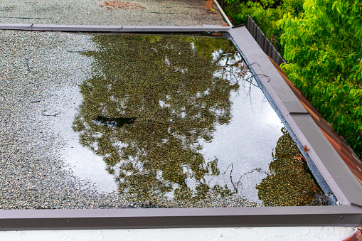 Estanque de agua estancada en un techo plano después de una fuerte lluvia photo